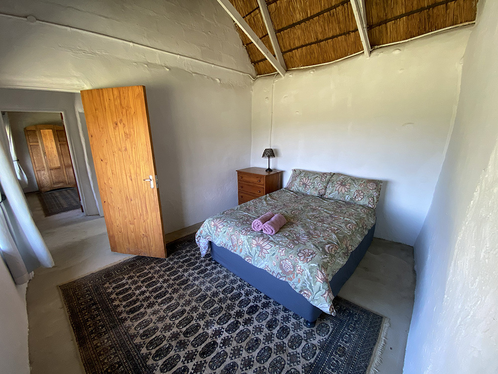 4-Bedroom Pet-Friendly Fisherman's Cottage: Heron - Bedroom with double bed under thatch