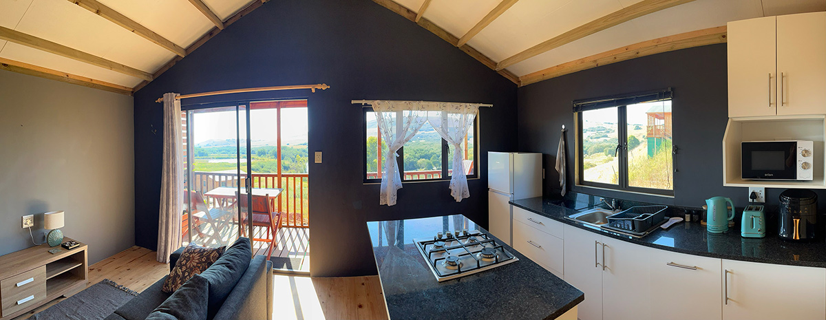 1-Bedroom Riverside Cabin 4: Shalom - Living area, kitchen and balcony doors