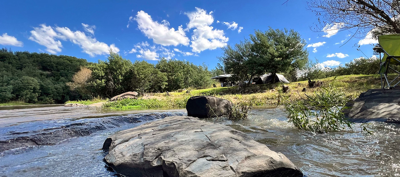 Riverside campsite with stone fire pit